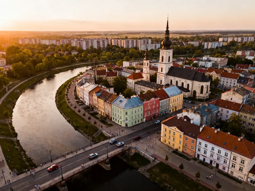 Panorama Gorzowa Wielkopolskiego o zachodzie słońca z rzeką, mostami i zabudową mieszkalną; no text on the picture